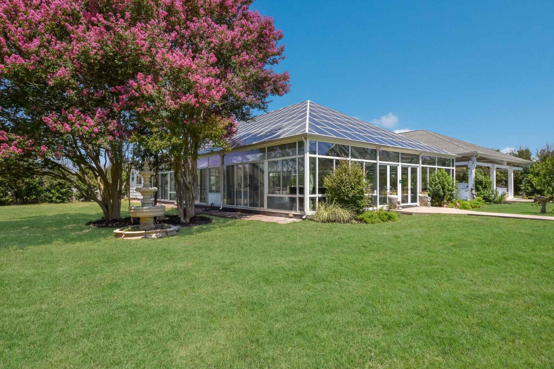 a beautiful house with big garden and a flower tree